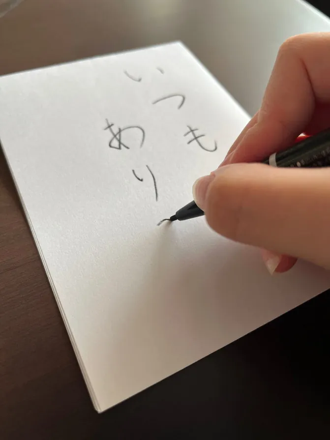 紙に言葉を書き込む手元